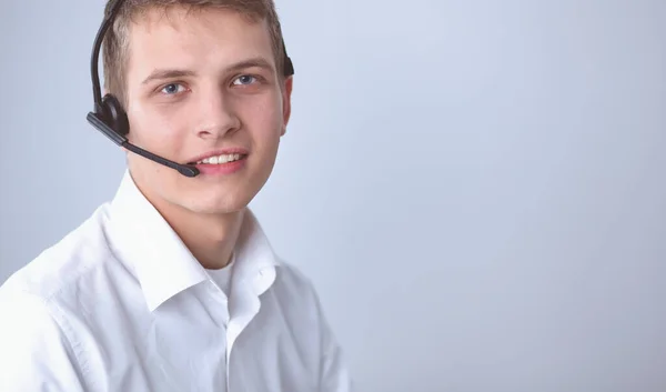 Portret van de jonge man die lacht zittend op een grijze achtergrond. Portret van jonge man — Stockfoto