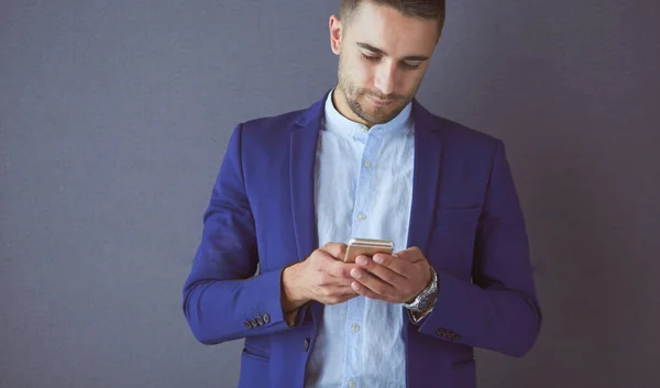 Joven empresario sentado aislado sobre fondo gris. —  Fotos de Stock