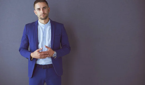 Joven empresario sentado aislado sobre fondo gris. — Foto de Stock