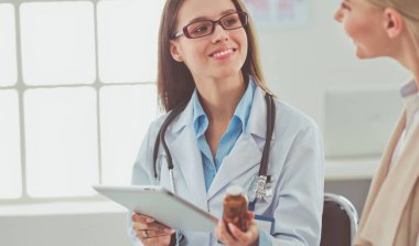 Doktor ve hasta masada otururken bir şey tartışıyorlar. İlaç ve sağlık hizmetleri kavramı