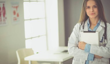 Hastane lobisinde tablet bilgisayar kullanan kadın doktor.