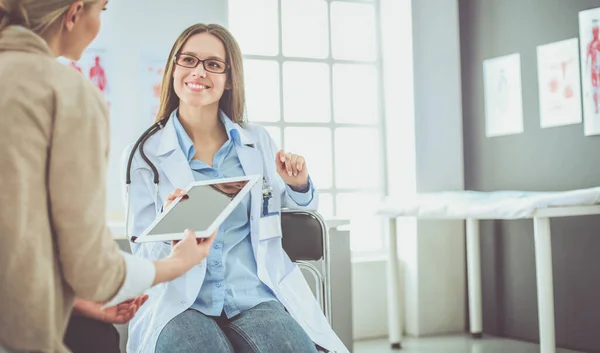 Médico e paciente discutindo algo enquanto se senta na mesa. Conceito de medicina e cuidados de saúde — Fotografia de Stock