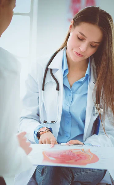 Arzt und Patient diskutieren etwas, während sie am Tisch sitzen. Medizin und Gesundheitskonzept — Stockfoto