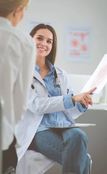 Dokter en patiënt bespreken iets terwijl ze aan tafel zitten. Begrip "geneeskunde en gezondheidszorg" — Stockfoto