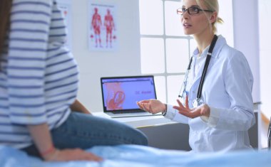 Hastanede doktorla gülümseyen güzel bir hamile kadın..