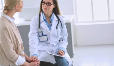 Doktor ve hasta masada otururken bir şey tartışıyorlar. İlaç ve sağlık hizmetleri kavramı.