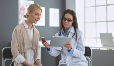 Doktor ve hasta masada otururken bir şey tartışıyorlar. İlaç ve sağlık hizmetleri kavramı.