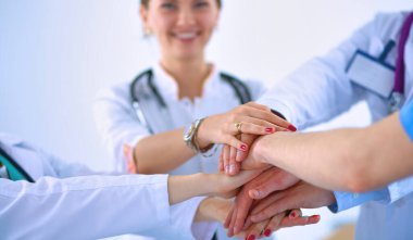 Doktorlar ve hemşireler tıbbi bir ekipte el ele tutuşuyorlar. .