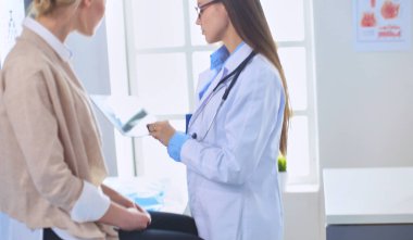 Doktor ve hasta masada otururken bir şey tartışıyorlar. İlaç ve sağlık hizmetleri kavramı.