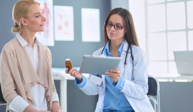 Doktor ve hasta masada otururken bir şey tartışıyorlar. İlaç ve sağlık hizmetleri kavramı.