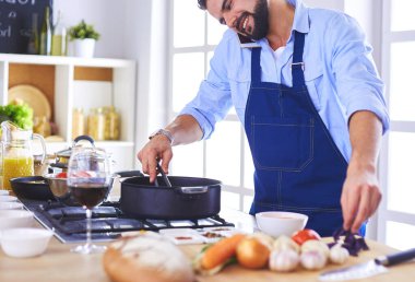 Adam ev mutfağında lezzetli ve sağlıklı yemekler hazırlıyor..