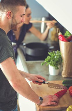 Bir çift evdeki mutfaklarında birlikte yemek pişiriyor..