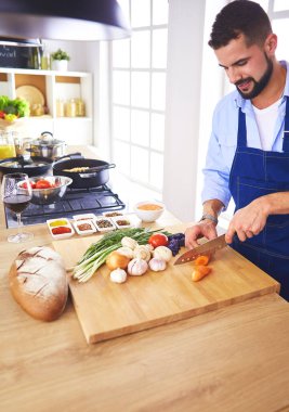 Adam ev mutfağında lezzetli ve sağlıklı yemekler hazırlıyor..