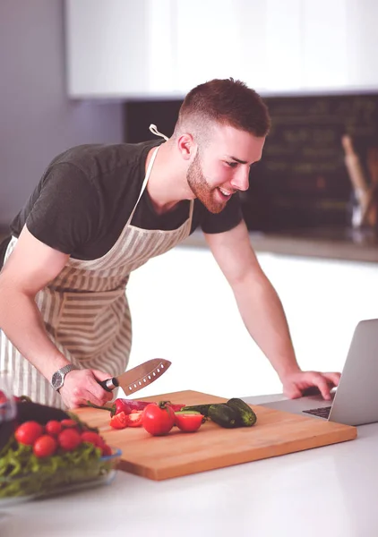 Retrato Del Hombre Cocinando Verduras Cocina Mientras Mira Una Computadora —  Fotos de Stock