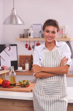 Mutfakta gülümseyen bir kadın, Noel arkaplanında soyutlanmış.