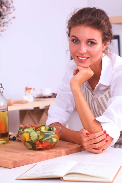 笑顔の若い女性がキッチンでサラダを準備します — ストック写真