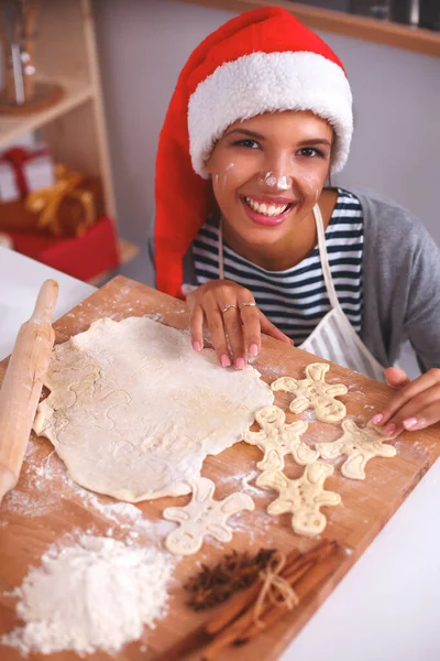 クリスマスのベーキングサンタの女性はサンタの帽子を身に着けているクリスマスの準備で楽しく笑って — ストック写真