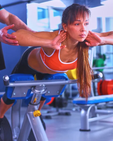 美丽的女人在健身房锻炼与她的教练 — 图库照片