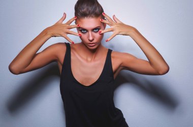 gri arka plan üzerinde duran güzel kadın .