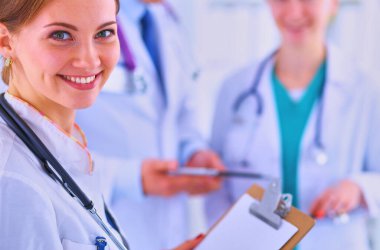 Tıbbî grubun önünde dosyası olan çekici bir kadın doktor. .