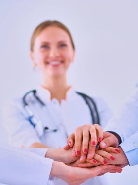 Doktorlar ve hemşireler tıbbi bir ekipte el ele tutuşuyorlar. .