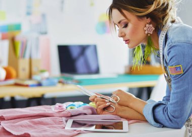 Moda Tasarımcısı kadın stüdyoda tasarımları ile iPad üzerinde.