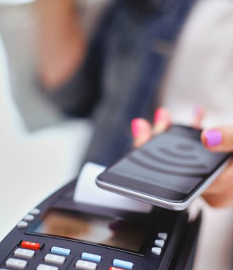 Müşteri ile smartphone Nfc teknolojisi kullanılarak dükkanda ödüyor. NFC teknolojisi. Müşteri ödeme.