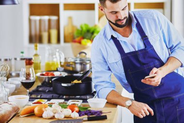 Mutfak arka planında poşet dolusu erzak tutan adam. Alışveriş ve sağlıklı gıda konsepti.