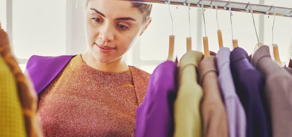 Vacker Ung Stylist Nära Rack Med Hängare — Stockfoto