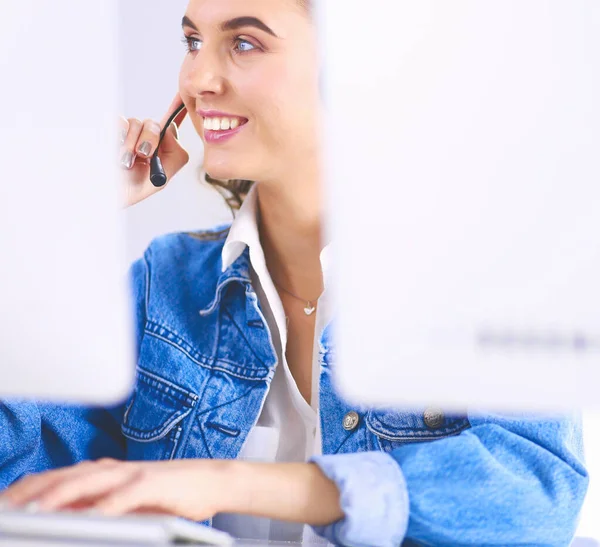 幸せな魅力的な若い女性座っているとオフィスでヘッドセットを使用してノートパソコンで作業 — ストック写真