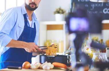 Mutfak arka planında poşet dolusu erzak tutan adam. Alışveriş ve sağlıklı gıda konsepti.