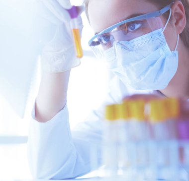 Modern laboratuvar veya hastanede plastik tıbbi tüplerle çalışan araştırmacı, doktor, bilim adamı veya laboratuvar asistanı.