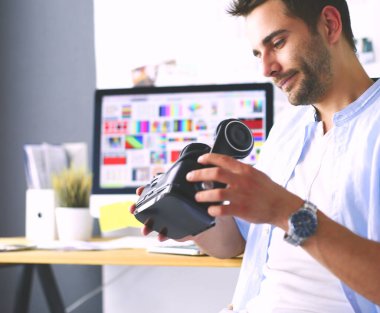 Genç erkek yazılım programcısı ofiste üç boyutlu sanal gerçeklik gözlükleriyle yeni bir uygulama test ediyor.