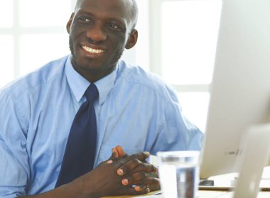 Kulaklıklı Afro-Amerikan işadamı laptopuyla çalışıyor..