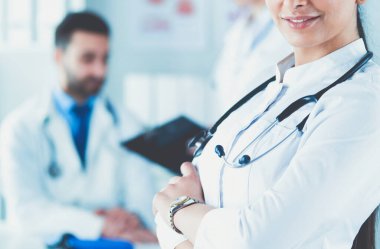 Steteskoplu kadın doktor kolları bağlı duruyor..