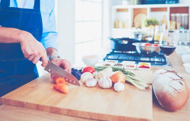 Adam ev mutfağında lezzetli ve sağlıklı yemekler hazırlıyor..