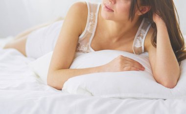 Güzel bir kadın yatağında uzanıyor..