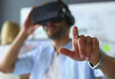 Genç erkek yazılım programcısı ofiste üç boyutlu sanal gerçeklik gözlükleriyle yeni bir uygulama test ediyor.