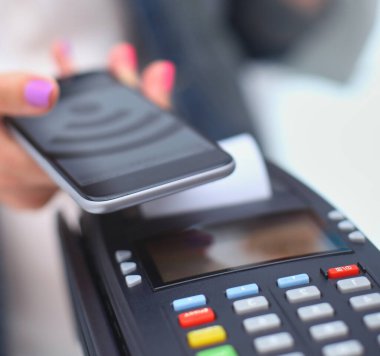 Müşteri ile smartphone Nfc teknolojisi kullanılarak dükkanda ödüyor. NFC teknolojisi. Müşteri ödeme.