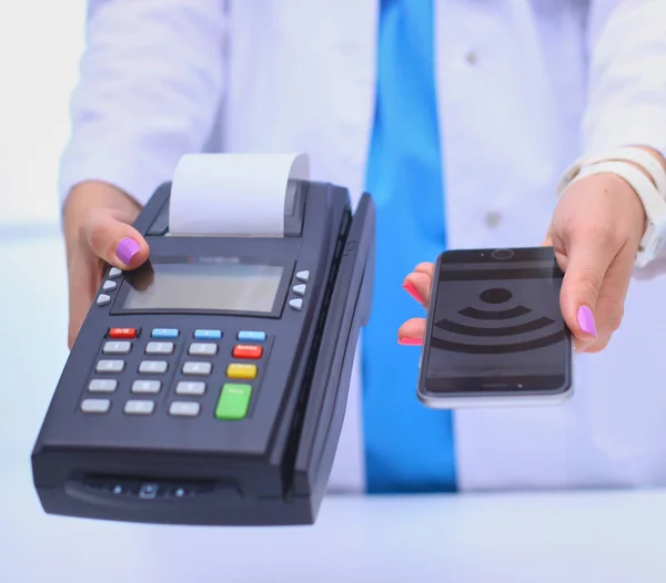 Doctor is holding payment terminal in hands. Paying for health care. Doctor.