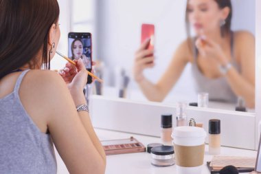 Ayna önünde akıllı telefon ile makyaj eğitimi filme Güzellik blogger .