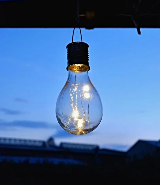 Led Light bulbs in an old decorative light bulb against a darkening sky.