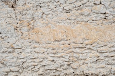 Old traditional limewashed stone wall, white rustic background or texture