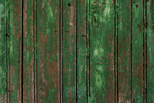 Old rustic wooden wall with green worn out paint