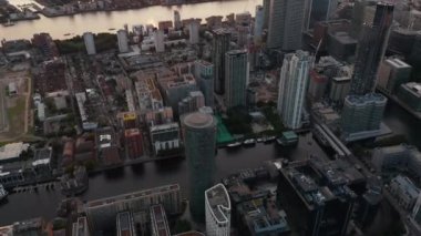 Canary Wharf iş bölgesindeki binalar arasındaki su kanalının yüksek açılı görüntüsü. Gün batımında hava manzarası. Londra, İngiltere