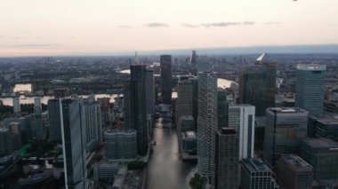 Canary Wharf iş bölgesindeki modern gökdelenlerin yükselen görüntüleri. Arka planda Thames Nehri kıvrılıyor. Londra, İngiltere