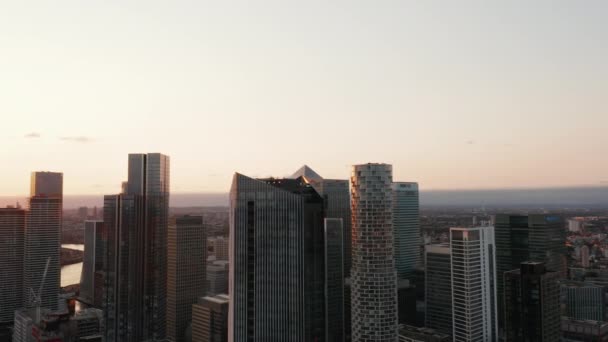 Slide och panorera bilder av grupp av höga moderna kontor och bostadshus i Canary Wharf finansiella centrum. Kvällsfilm i solnedgången. London, Förenade kungariket — Stockvideo