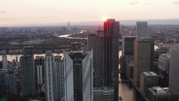 Σύγχρονοι ουρανοξύστες στην περιοχή Κανάρι Γουόρφ. Εμπρός πετούν πάνω από το Isle of Dogs κατά τη δύση του ήλιου. Λονδίνο, Ηνωμένο Βασίλειο — Αρχείο Βίντεο
