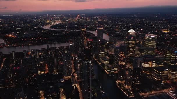 Повітряні панорамні кадри міста вночі. Skyscrapers в бізнес-центрі Canary Wharf з домінантним освітленим пірамідним дахом на площі One Canada Square. Cityscape at dusk Лондон, Велика Британія — стокове відео