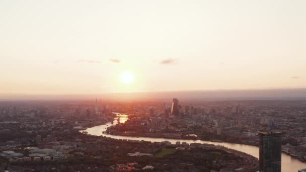 Vista panorámica aérea del río Támesis que fluye tranquilamente por la ciudad. Paisaje urbano contra la puesta de sol. Londres, Reino Unido — Vídeos de Stock